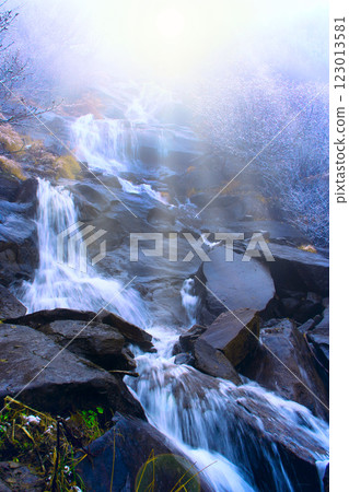 Landscape with waterfall and river flowing in mountains in sunny rays 123013581
