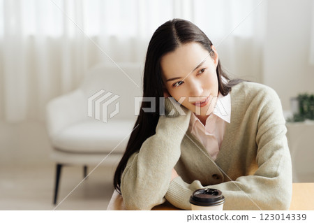 Businesswoman sitting at a table and thinking Businesswoman sitting at a table and thinking 123014339