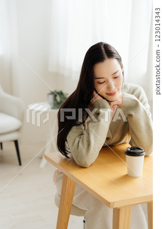 Businesswoman sitting at a table and thinking Businesswoman sitting at a table and thinking 123014343