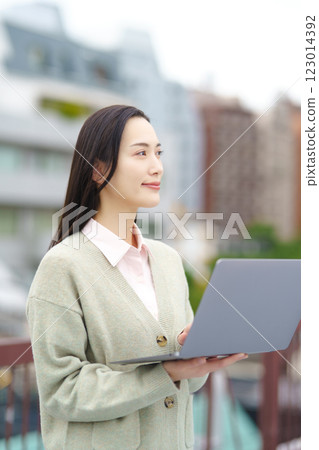 Image of a city, a computer and a businesswoman Image of a city, a computer and a businesswoman 123014392