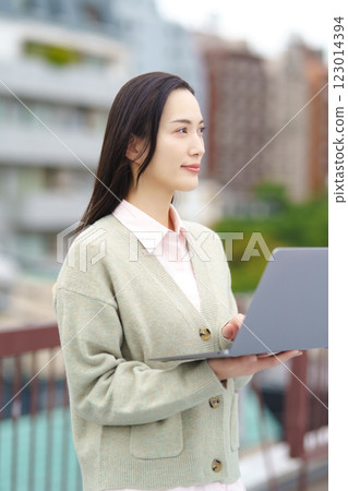 Image of a city, a computer and a businesswoman Image of a city, a computer and a businesswoman 123014394