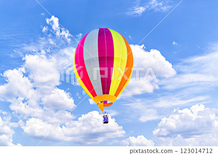 Colorful hot air balloon flying over blue sky with white clouds 123014712