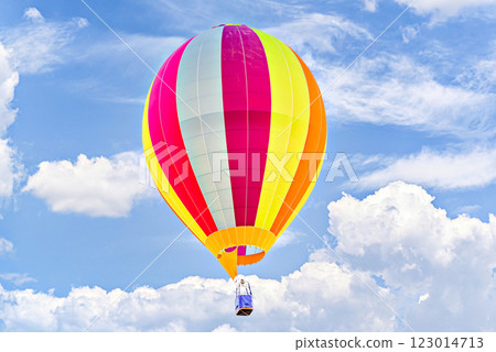 Colorful hot air balloon flying over blue sky with white clouds 123014713