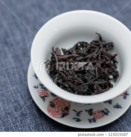 A beautifully crafted bowl holds dried black tea leaves, highlighting elegance and culture 123015087