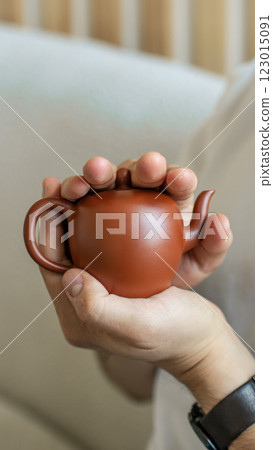 This Handcrafted Teapot in Hands showcases an Elegant Design, perfect for Tea Lovers everywhere This Handcrafted Teapot in Hands showcases an Elegant Design, perfect for Tea Lovers everywhere 123015091