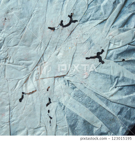 Bold black ink splashes on wrinkled paper create dynamic abstract artistic textures 123015195
