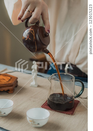 Experience a delightful and elegant tea pouring moment in a serene and tranquil setting 123015223