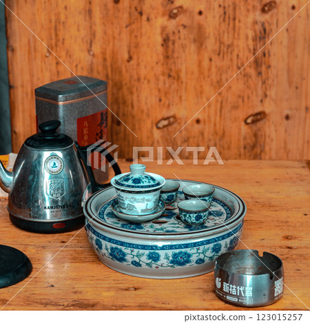 A traditional tea set complete with a kettle elegantly displayed on a rustic wooden table A traditional tea set complete with a kettle elegantly displayed on a rustic wooden table 123015257