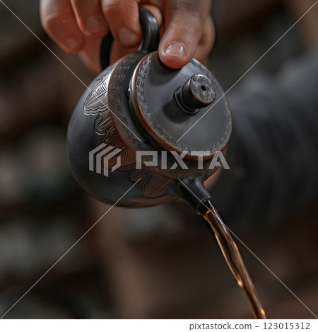 Artisanal Teapot Pouring Tea in a Cozy, Inviting Setting for a Relaxing Experience Artisanal Teapot Pouring Tea in a Cozy, Inviting Setting for a Relaxing Experience 123015312