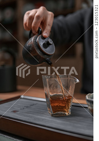 The Artisan Tea Pouring Process Unfolds in a Cozy Setting, Enriching the Experience 123015321