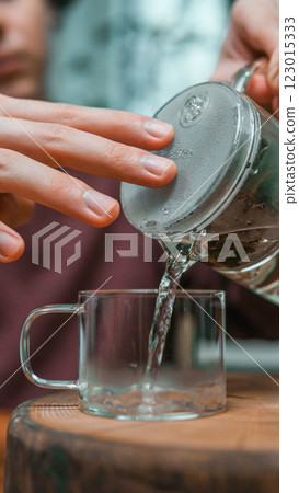 Pouring hot water carefully into a beautiful glass cup can be a delightful experience 123015333