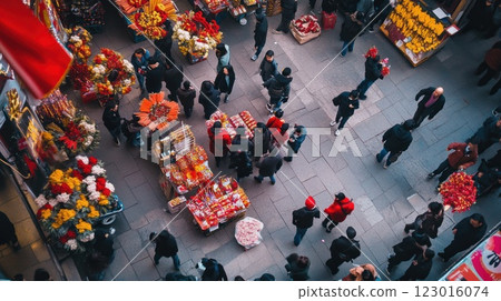 Aerial view of a bustling Asian street market with crowds of people shopping for flowers and food. 123016074