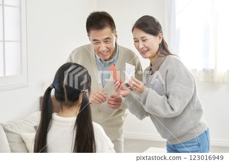Grandmother and grandfather giving New Year's money to their grandchild Grandmother and grandfather giving New Year's money to their grandchild 123016949