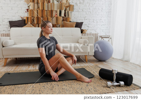 Yoga practice in a modern living room designed for relaxation and openness, enhancing wellness 123017699