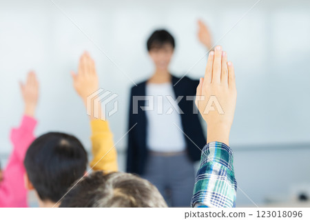 Image of elementary school students raising their hands in the classroom 123018096