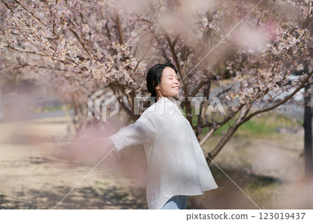 沿著櫻花樹散步的年輕女子 沿著櫻花樹散步的年輕女子 123019437