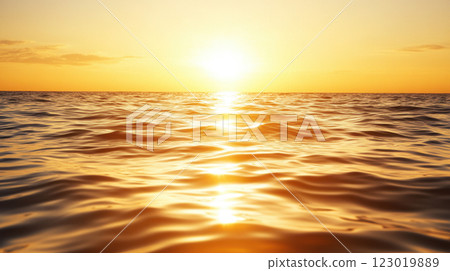 Golden sunset reflecting on calm ocean waves creates serene atmosphere 123019889