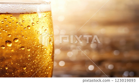 Golden liquid droplets glisten on glass, creating refreshing atmosphere 123019893