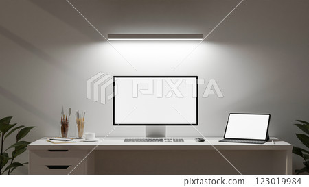 A minimalist white office features a computer and a digital tablet set on a desk. 123019984