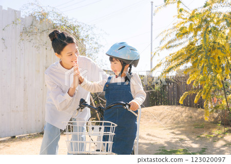 Parent and child practicing riding a bicycle 123020097