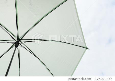 open green umbrella in rainy day with white cloud and blue sky 123020252