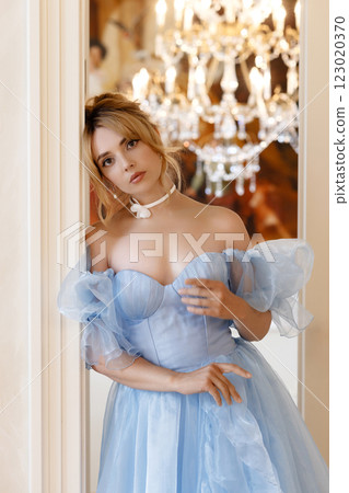 Elegant woman in a light blue ball gown in a luxurious classic interior 123020370
