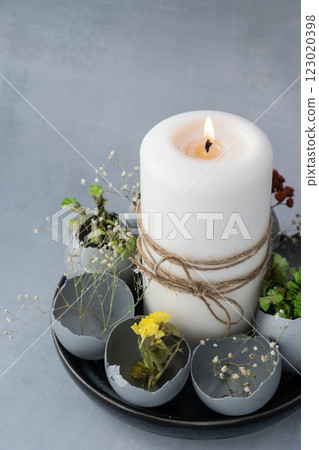 Creative handmade Easter table decoration with egg shells instruction candle on grey background. Easter home decoration. Copy space greeting card Seasonal sustainable recycled 123020398