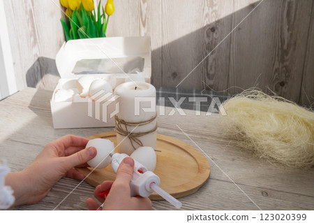 Female hands making egg shell handmade decoration for Easter holiday. Tutorial master class storytelling. Zero waste sustainable eco-friendly me made decor. Minimalistic 123020399