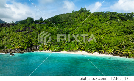 Coastline surrounded by lush vegetation and white sandy beach. Seychelles, Mahe. Butzel Beach. 123021123