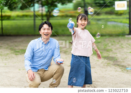 Parents and children playing with soap bubbles 123022710