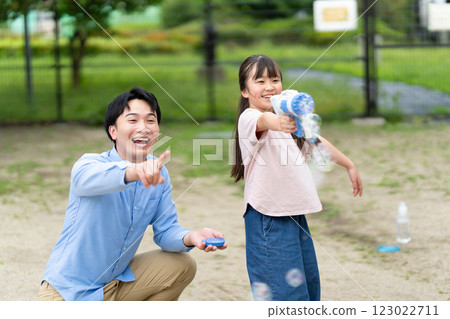 Parents and children playing with soap bubbles 123022711