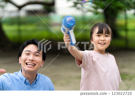 Parents and children playing with soap bubbles 123022720