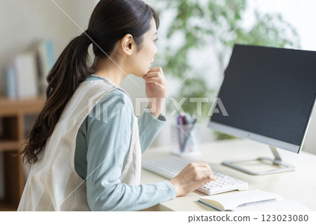 一名年輕女子走向一台電腦 123023080