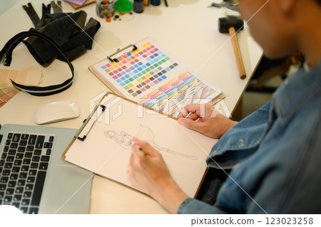 Creative fashion designer sketching a clothing design on paper while working at studio 123023258