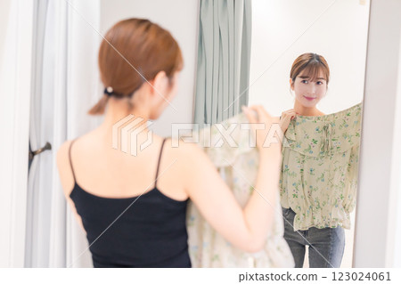 Young woman trying on clothes in a fitting room 123024061