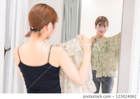 年輕女子在試衣間試穿衣服 年輕女子在試衣間試穿衣服 123024062