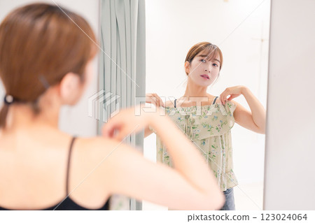 Young woman trying on clothes in a fitting room 123024064