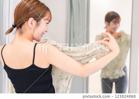 年輕女子在試衣間試穿衣服 年輕女子在試衣間試穿衣服 123024068
