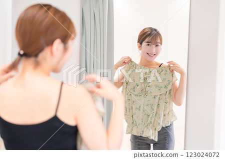 年輕女子在試衣間試穿衣服 123024072