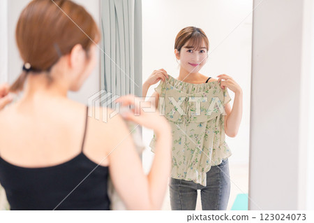 Young woman trying on clothes in a fitting room 123024073