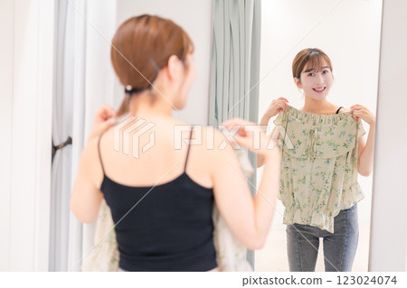 Young woman trying on clothes in a fitting room 123024074