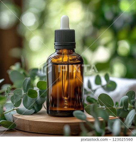 Natural essential oil dropper bottle on wooden surface greenery background product photography 123025560