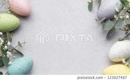 Easter eggs and eucalyptus leaves forming a frame on gray background 123027487