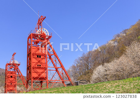A shaft hoisting machine stands tall in the Coal Mine Memorial Forest Park, where kobushi trees bloom, in Bibai City, Hokkaido [May] 123027838
