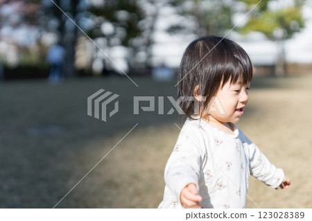 A one-year-old Japanese girl playing on the grass in a park 123028389