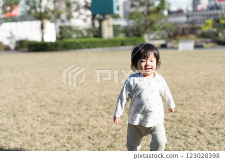 A one-year-old Japanese girl playing on the grass in a park 123028398