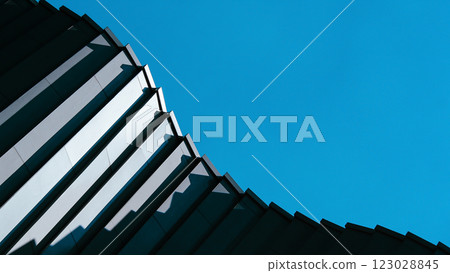 A repetitive glass facade creates a mesmerizing geometric pattern. The diagonal angle enhances depth and visual rhythm. 123028845