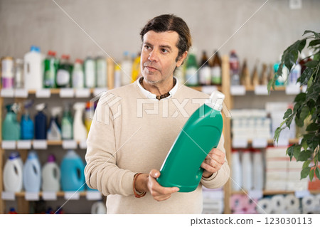 Man choosing cleaning product in supermarket Man choosing cleaning product in supermarket 123030113