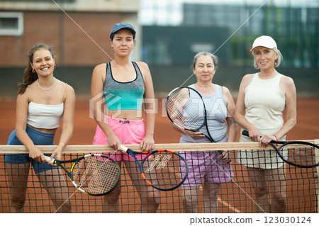 Group of women posing on tennis court 123030124