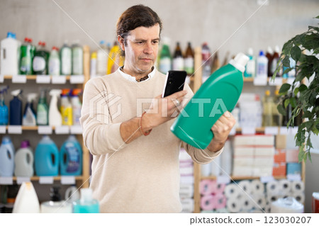 Man uses barcode to get information about liquid detergent in mobile application. 123030207